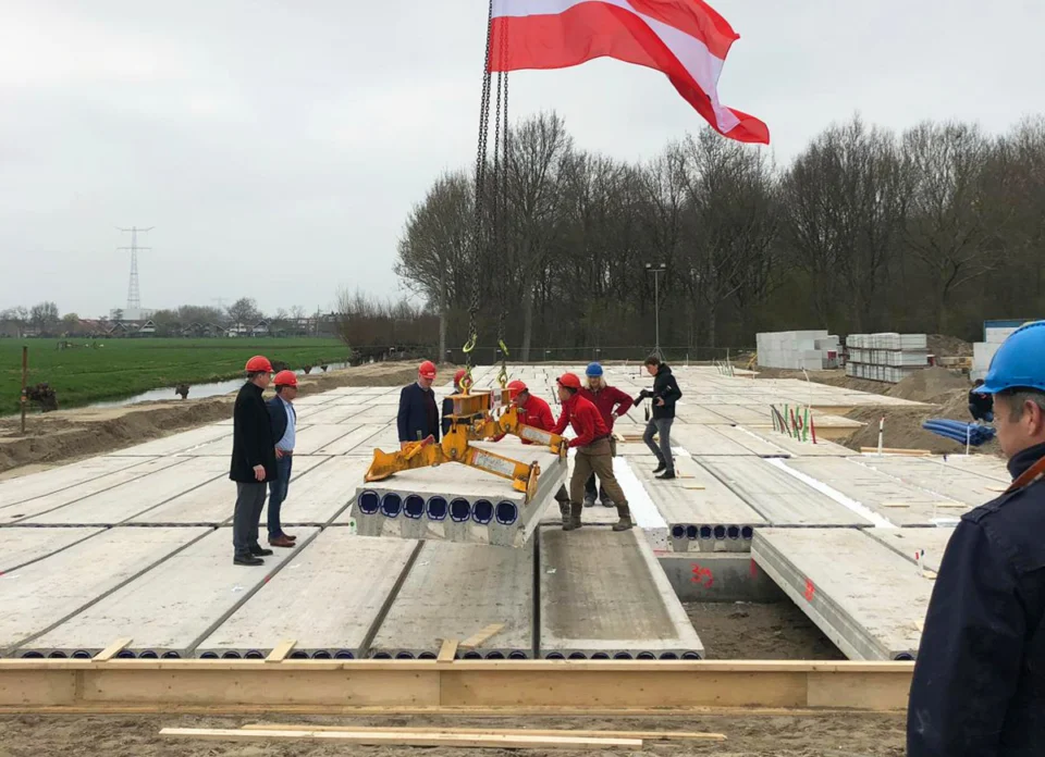 Het leggen van de laatste vloerplaat van de koopappartementen