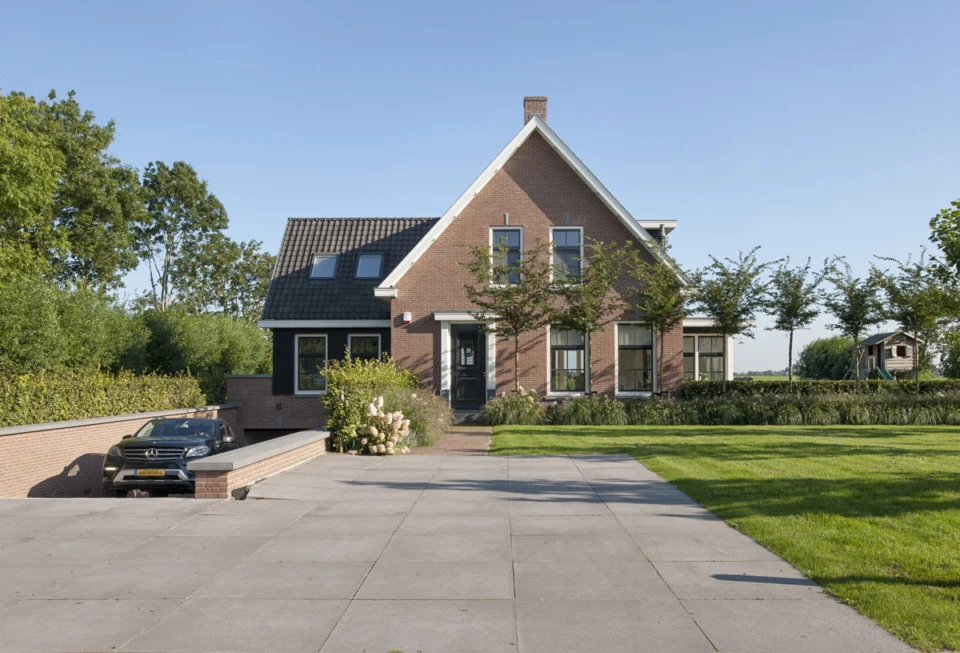 Inrit garage in de kelder Woning - vooraanzicht met aan de linkerzijde de inrit naar de naar de garage / kelder