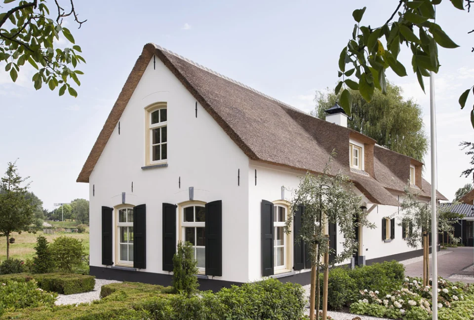 Witte landelijke woning rieten dak