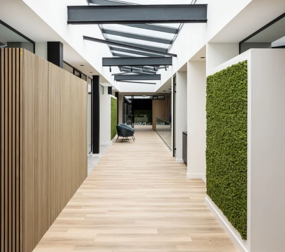 Centrale hal van het kantoor van WEA met houtaccenten en wanden met mos bekleding - foto via Jaleco Centrale hal van het kantoor van WEA met houtaccenten en wanden met mos bekleding - foto via Jaleco