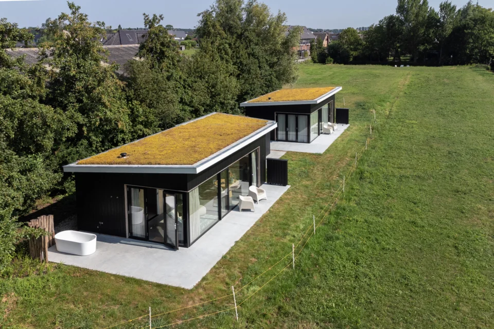 Twee vakantiewoningen met groendaken in polderlandschap vogelperspectief