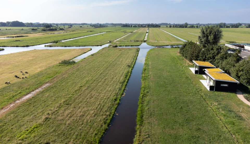 Droneshot van twee vakantiewoningen aan de rand van een polderlandschap Droneshot van twee vakantiewoningen aan de rand van een polderlandschap