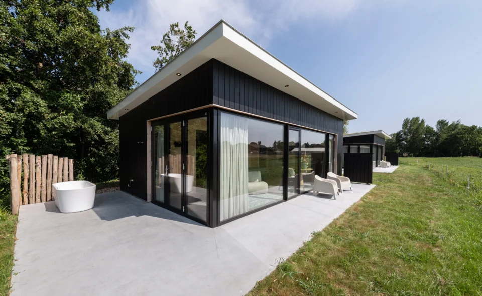 Zwarte vakantiewoning met houten omlijsting van raampartij