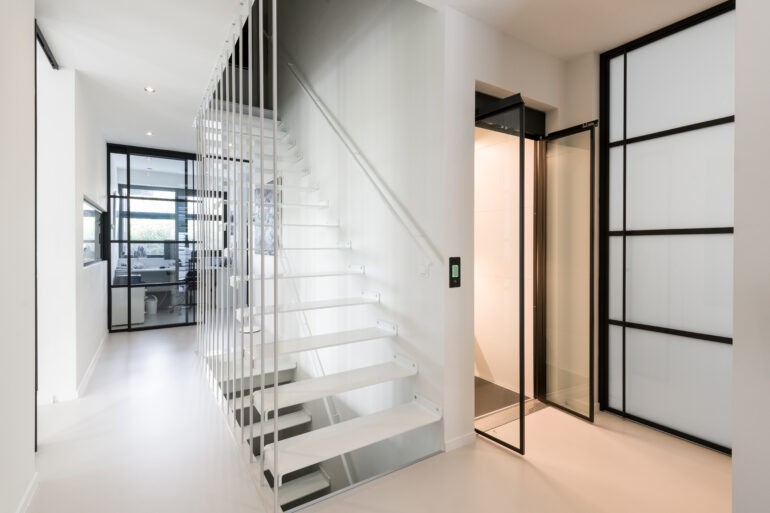 Interieur van de schuurwoning met trap en lift